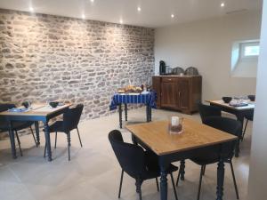 朱里耶纳La maison de Bruno的一间有桌椅和砖墙的餐厅