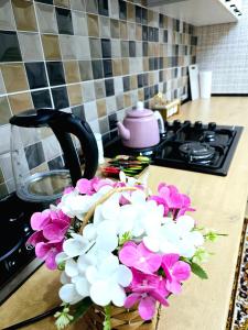 a bouquet of flowers in a basket on a kitchen counter at Golden house deluxe 2 in Bukhara