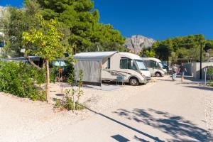 a group of camper vans parked in a parking lot at Medora Orbis Camping Pitches in Podgora +10 photos