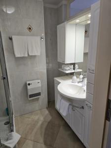 bagno bianco con lavandino e specchio di Depandance Garni Golf ad Ascona Altre 37 foto