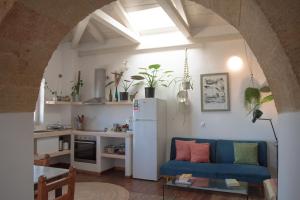a living room with a blue couch and a white refrigerator at Ataraxia in Aroniadika
