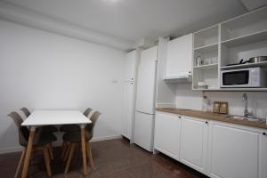 a kitchen with white cabinets and a table and chairs at Residencia Universitaria Resa Colegio de Cuenca in Salamanca