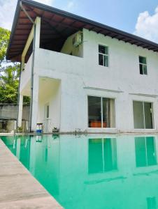 a house with a swimming pool in front of it at Villa Idda in Padukka