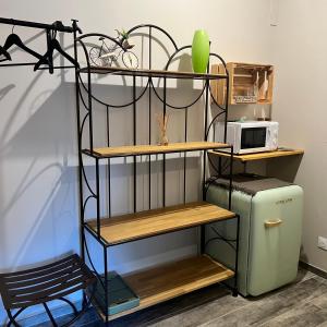 a shelf next to a microwave and a refrigerator at Le Mas de Scott in Espeluche