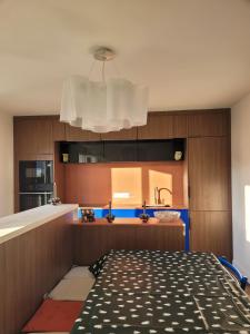 een keuken met een bed, een gootsteen en een kroonluchter bij Oacys in Le Barcarès