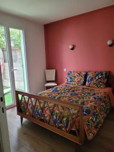 een slaapkamer met een bed met een rode muur bij Oacys in Le Barcarès