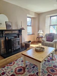a living room with a coffee table and a fireplace at Rustic Pub Stay - 20 minutes from Killarney! in Rathmore