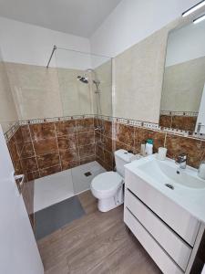 Un baño con inodoro, lavabo y ducha. en Everything You Need All Right Here, en Las Galletas