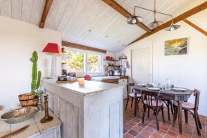 a kitchen with a counter and a table with chairs at L’Échappée du Port - Grand Jardin in Bouin +7 photos