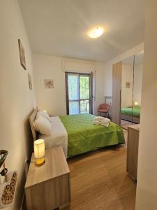 a bedroom with a large bed with a green blanket at Sara&Pietro's Home in Diano Marina