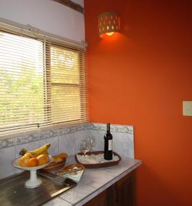 a kitchen counter with a bottle of wine and a bowl of fruit at Snug Bungalow - 4 people - Pool - SuperHost in Mala +10 photos