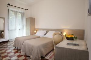 a hotel room with two beds and a table with a mirror at Villa Astoria in Taormina