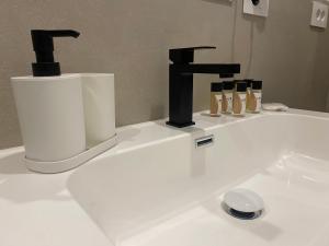 a white bathroom sink with a black faucet at B&B Platani in Avellino