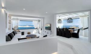 ein weißes Wohnzimmer mit Tisch und Stühlen in der Unterkunft Magnificent Mykonos Villa Villa Rikei 5 Bedrooms Unique Aegean Sea Views in Psarrou