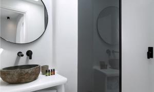 ein Badezimmer mit einem Waschbecken und einem Spiegel in der Unterkunft Magnificent Mykonos Villa Villa Rikei 5 Bedrooms Unique Aegean Sea Views in Psarrou + 23 Fotos