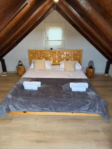 une chambre avec un grand lit dans un grenier dans l'établissement Mrdina house, à Kali