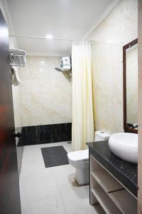 une salle de bain avec un lavabo, des toilettes et une douche dans l'établissement Barga Forest Inn, à Jāmb