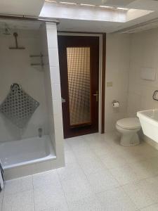 a bathroom with a tub and a toilet and a sink at Casa monte Podona in Selvino +3 photos