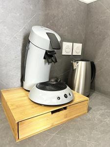 a white coffee maker sitting on a wooden stand at Studio Bohème in Gare du Nord +1 photo