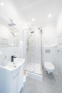a white bathroom with a shower and a toilet at Apartament 01, Rodzinny z Tarasem, Grzybowo Centrum - Nadmorska 26 in Grzybowo