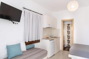 a living room with a couch and a tv and a kitchen at Naxos Central Room Superior Triple Room Balcony 200M From St George Beach City Views Saint George in Naxos Chora