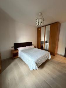 a bedroom with a large bed and a chandelier at Alojamiento valladolid in Valladolid