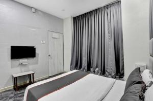 a bedroom with a large bed and a television at Hotel Unicorn, Surat in Surat