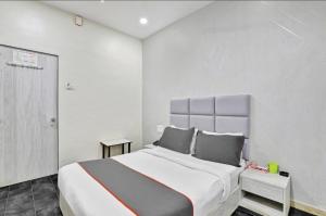 a white bedroom with a large bed in it at Hotel Unicorn, Surat in Surat
