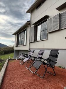 a group of chairs sitting outside of a house at サウナパラダイス富山 in Minamiboso