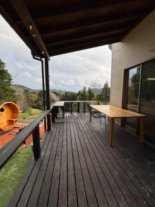 a wooden deck with a bench and a table at サウナパラダイス富山 in Minamiboso
