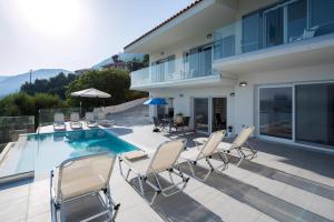 a patio with chairs and a swimming pool at Cp 8 Bedrooms NL Villas All Pirgi in Pyrgi