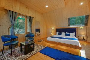 a bedroom with a bed and two chairs in a room at SaffronStays Bagh Kufri - Deluxe Suites in Kūfrī +25 photos