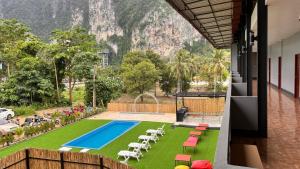 a view from the balcony of a hotel with a pool and chairs at Fahsai Hostel in Ao Nang Beach