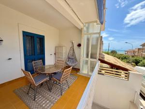 a balcony with a table and chairs and a blue door at Sabbia Sole e Sale, Casa a 5' dalla Spiaggia di Sampieri in Sampieri