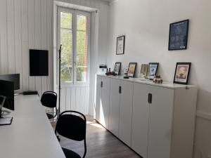 La Villa Madeleine في جوسيير: غرفة بها دواليب بيضاء وطاولة ونافذة