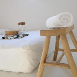 a wooden stool with towels on top of a bed at Cute Antiparos Villa 1 Bedroom Villa Sunset Amazing Sea Views in Andiparos