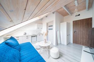 a living room with a blue couch and a table at Apartament 01, Rodzinny z Tarasem, Grzybowo Centrum - Nadmorska 26 in Grzybowo