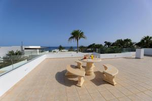 patio ze stołem i ławkami na dachu w obiekcie Luxury Puerto Calero Villa Casa Nublo 3 Bedrooms Private Pool Terrace With Seaviews Lanzarote w mieście Puerto Calero