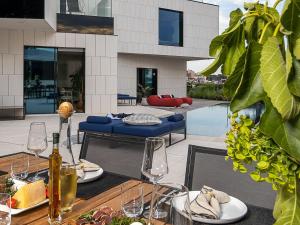 un patio con un tavolo con piatti di cibo e bicchieri di vino di Antal Fazana Istria a Fažana
