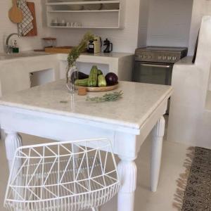 Stunning Antiparos Villa 3 Bedrooms Villa Kamino Breathtaking Sea Views في أنديباروس: مطبخ مع طاولة مع وعاء من الخضروات +24 صورة