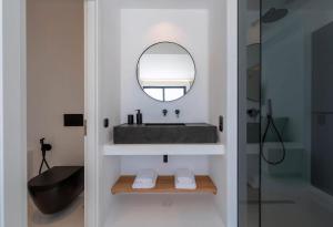 ein Badezimmer mit Waschbecken und Spiegel in der Unterkunft Extraordinary Mykonos Villa Villa Shifu 6 Bedrooms Unique Aegean Sea View in Ano Mera + 25 Fotos