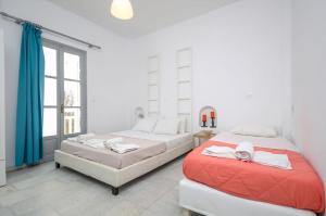 a white bedroom with two beds and a window at Luxury Naxos Apartment Deluxe Triple Studio 150M From St George Beach City Center Saint George in Naxos Chora