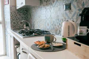 a kitchen with a stove and a plate of food at Le Case delle Rose in Civitavecchia