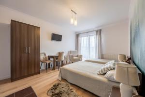 a bedroom with a bed and a dining room at Gabrysia in Bukowina Tatrzańska
