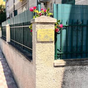Un muro de piedra con flores encima de una valla. en Le Case delle Rose, en Civitavecchia