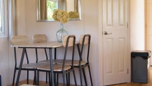 a dining room table with two chairs and a vase at Camping Alkenhaer Appelscha Chalet 034 in Appelscha +6 photos