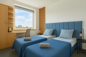 a hotel room with two beds and a window at Sapphire Hotel Room Poznan in Poznań