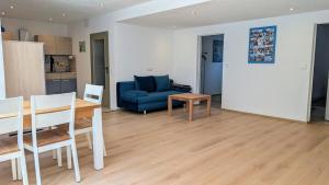 a living room with a blue couch and a table at Zentrumsnahe, ruhige Souterrainwohnung AlBaggers in Dinkelsbühl