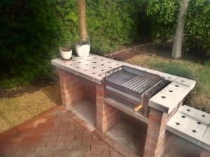 an outdoor grill with a table and two potted plants at Snug Bungalow - 4 people - Pool - SuperHost in Mala