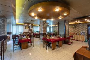 a restaurant with tables and chairs and a large chandelier at SEL Nibash Hotel & Serviced Apartments in Dhaka